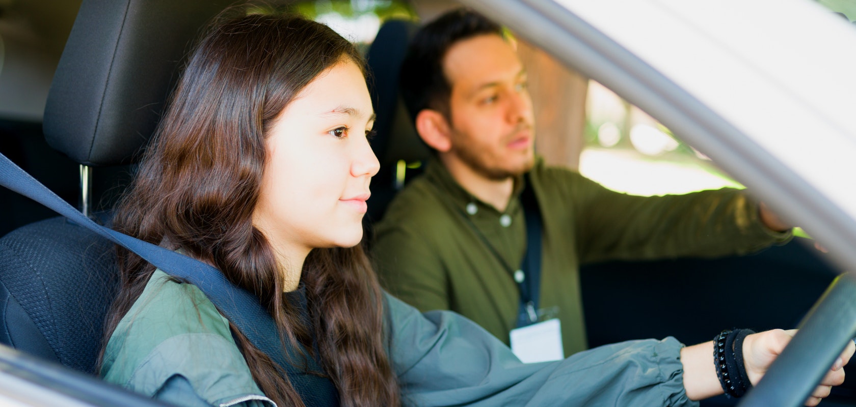 Driving instructor and student in car during driving lesson